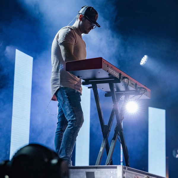 Low angled picture of our male solo keyboardist for events onstage performing as bright stage lights shine down on him | Altus Entertainment